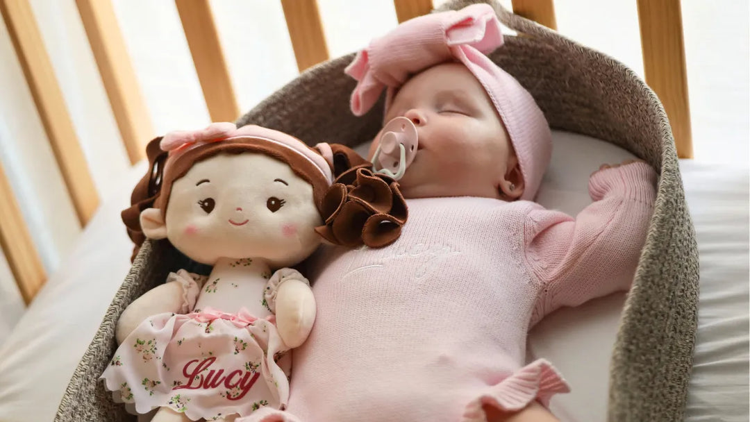 Baby girl sleeping beside personalized Princess Breeze plush doll in a crib