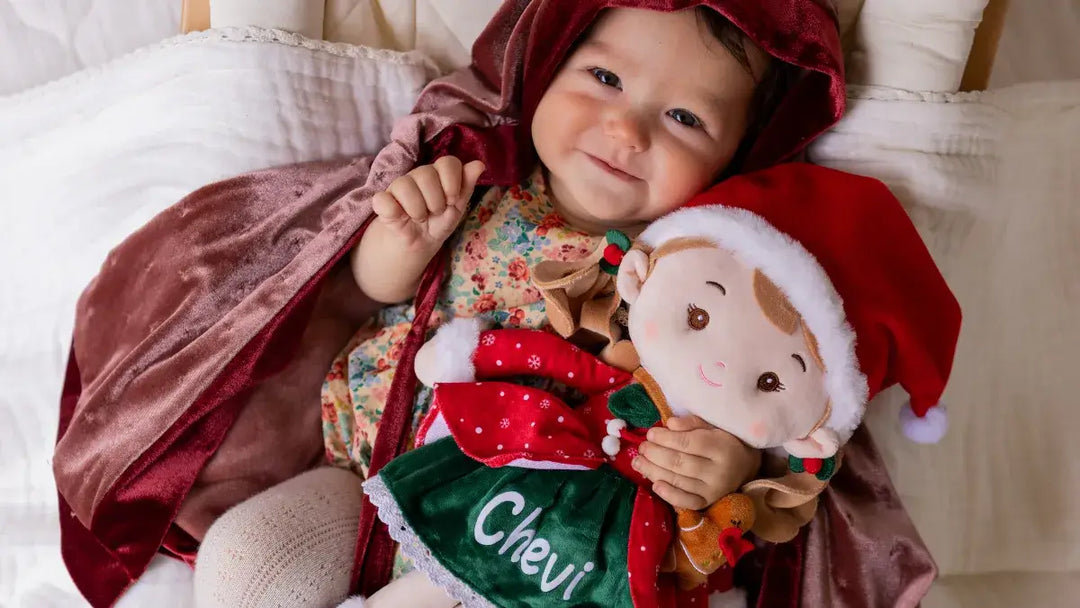 Baby girl playing Christmas Doll Natalie the Elf plush doll during playtime