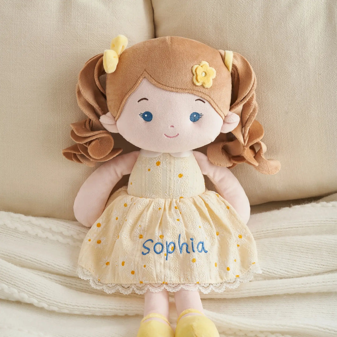 Daisy Girl plush doll with embroidered name displayed on a cozy sofa