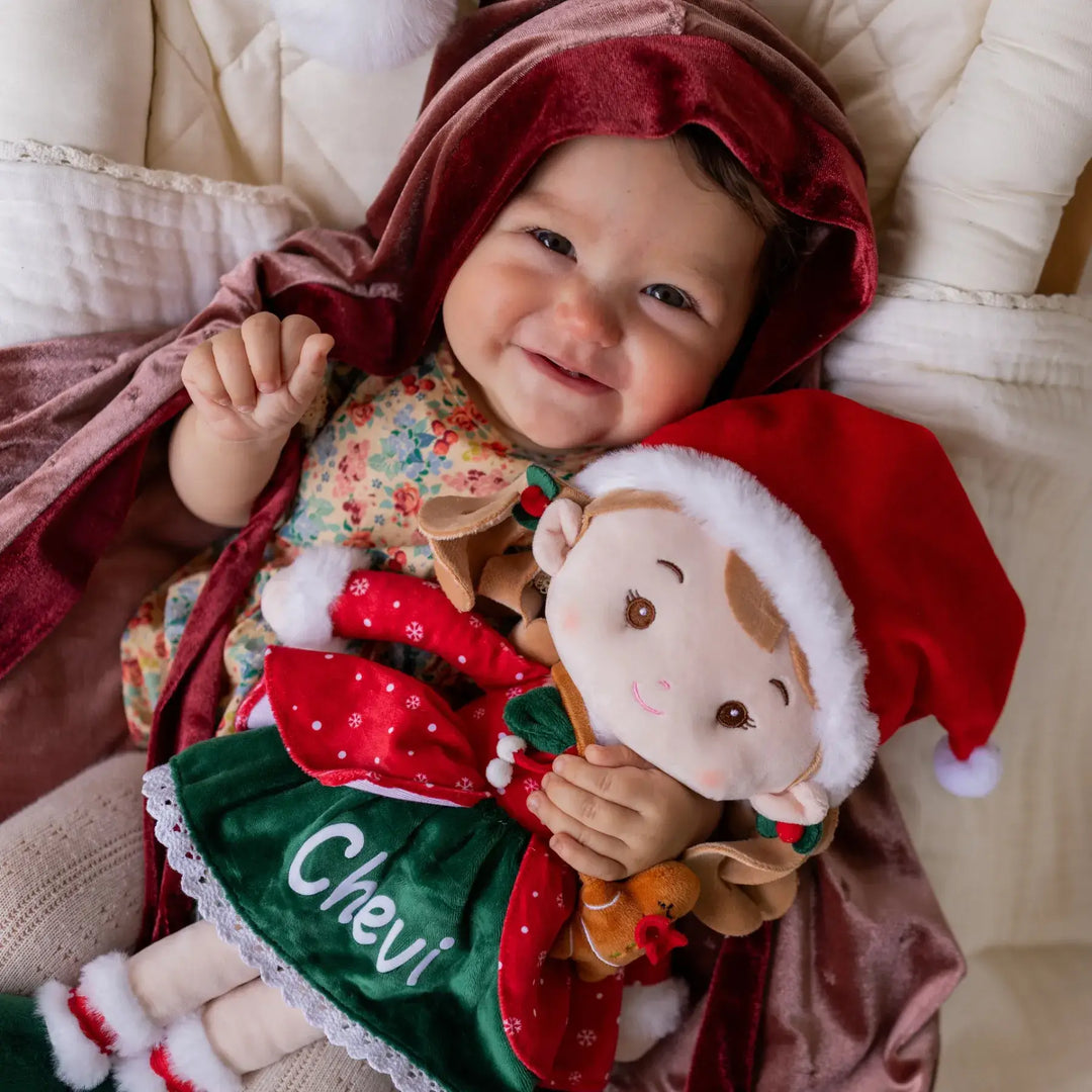 Baby girl playing Christmas Doll Natalie the Elf plush doll during playtime