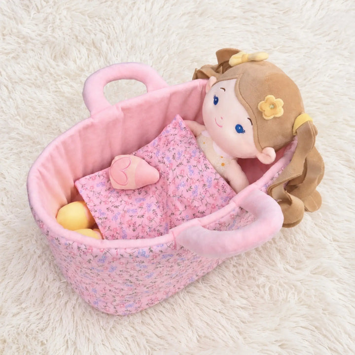 Daisy Girl plush doll lying in 13-inch Caregiver Playset bassinet with matching blanket for pretend doll care