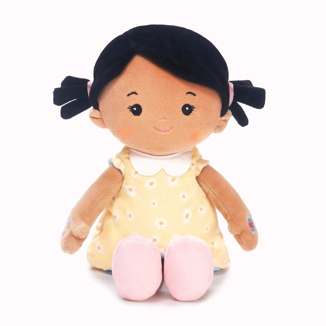 Mia soft talking doll in free extra yellow floral reversible outfit, seated front view