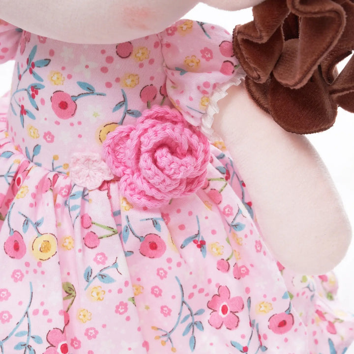 Princess Camelia baby doll wearing a floral dress with crocheted camellia flower