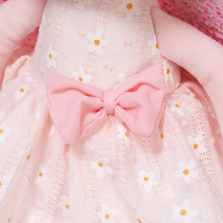 Maisie Butterfly baby doll wearing a daisy dress with pink bow
