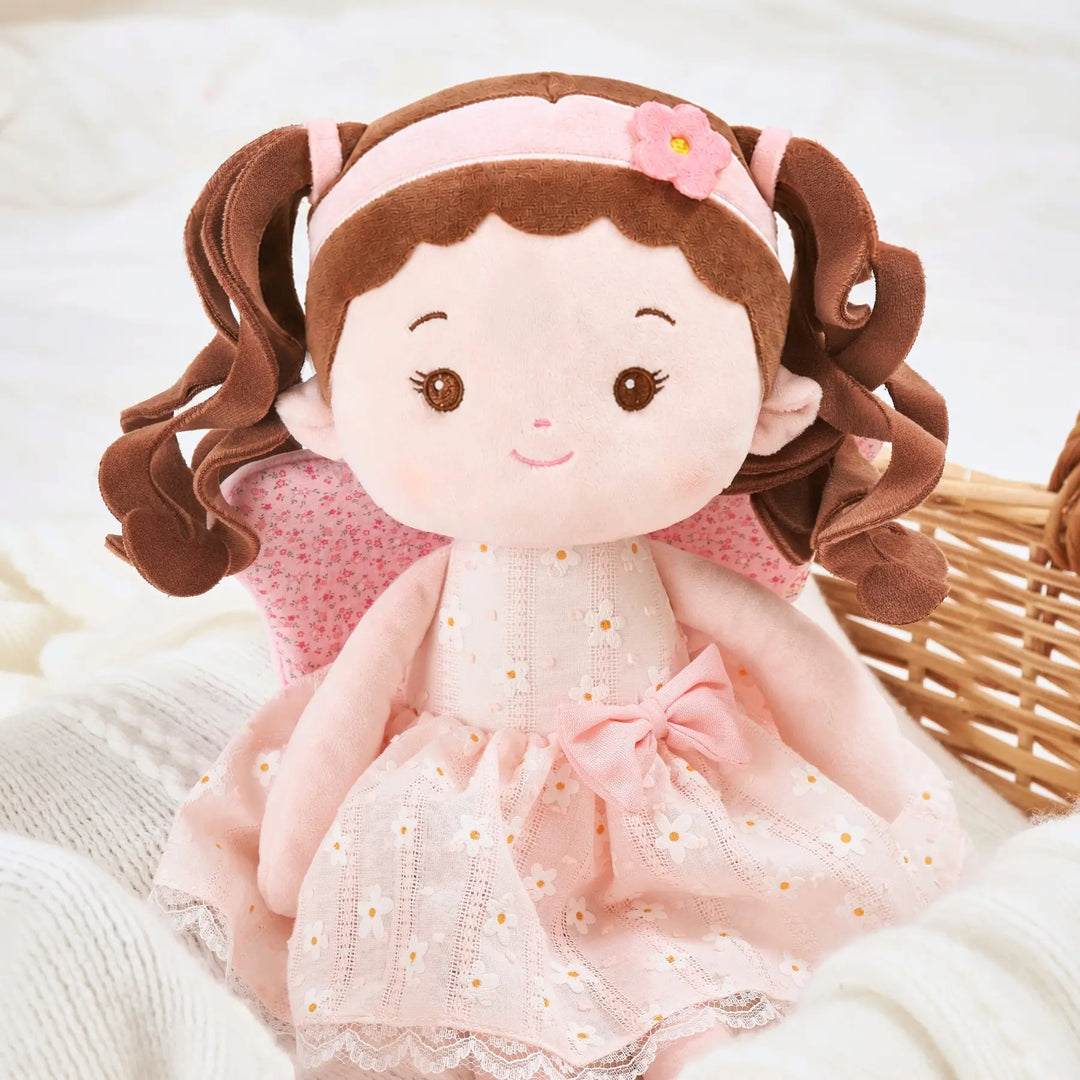 Maisie Butterfly soft baby doll seated on bed for cuddles and pretend play