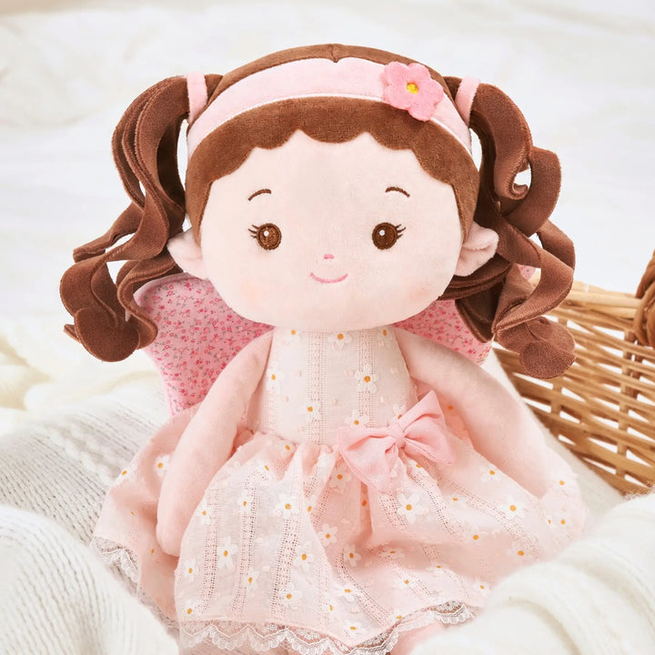 Maisie Butterfly soft baby doll seated on bed for cuddles and pretend play