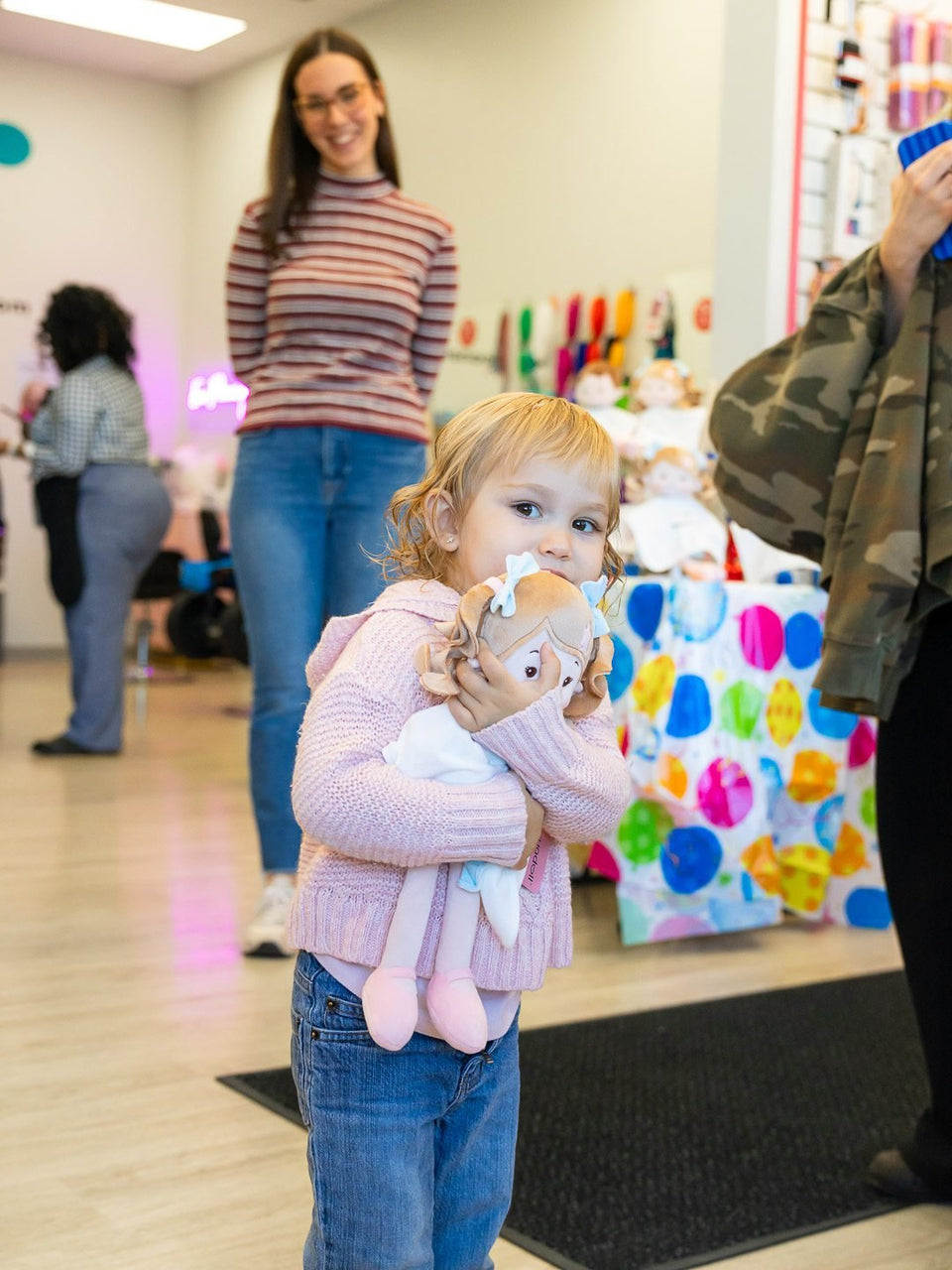 Toddler hugging her Beaners Leyadoll at the salon