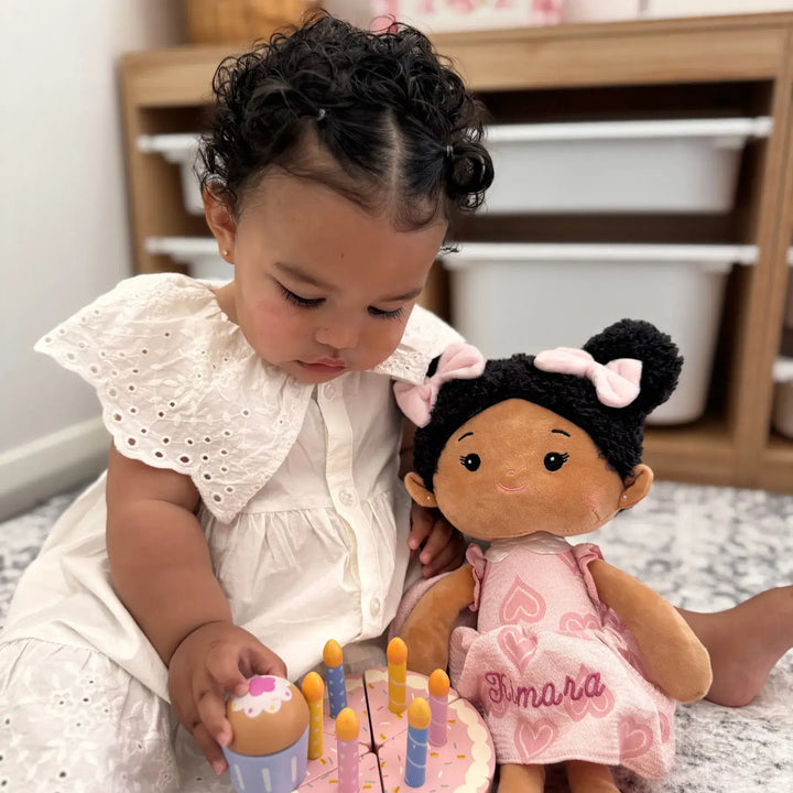 Baby girl playing with Chloe Sweetheart plush doll during pretend play